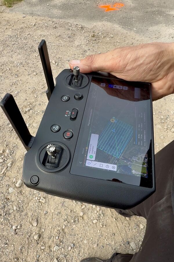DJI-Fernsteuerung zeigt eine automatisch geplante Flugroute in parallelen Bahnen während der photogrammetrischen Befliegung